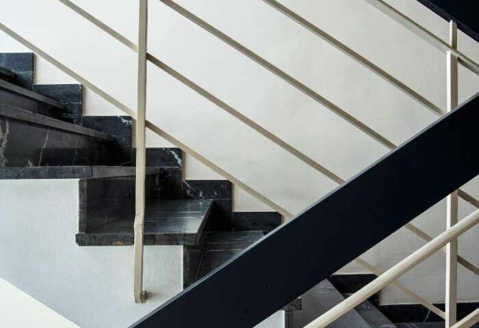 Staircase detail at LiV'iN Residence Frankfurt, a gay-friendly hotel on Seilerstraße. Black marble steps and metal railings.