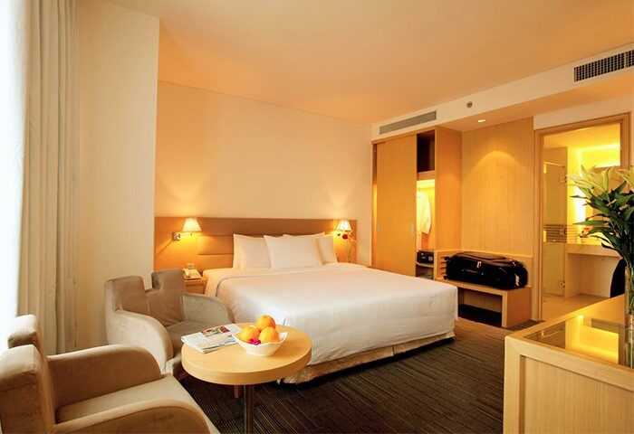 Liberty Central Saigon Centre Hotel's gay-friendly room. Modern design with a bed, chairs, table, and closet. Ideal for gay travelers.