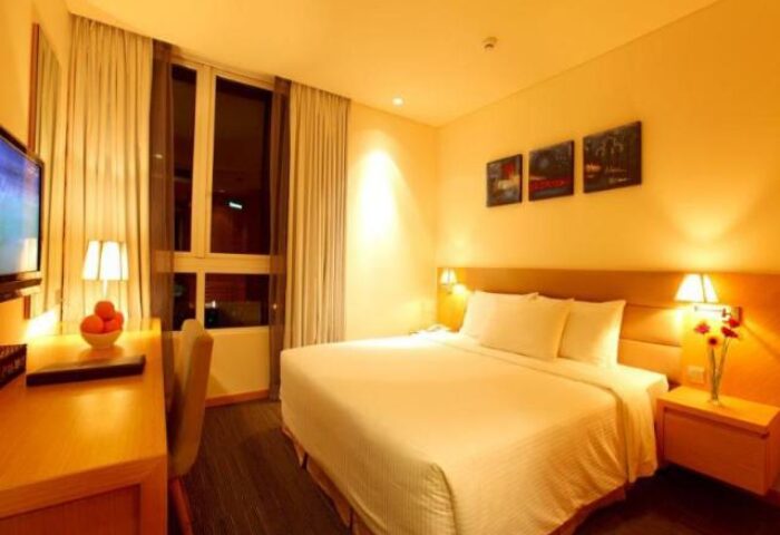 Liberty Central Saigon Centre Hotel room. Gay-friendly hotel, Saigon, Vietnam. Modern interior, comfy bed, desk, & city view window.