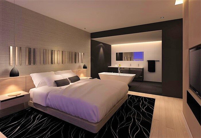 Liberty Central Saigon Citypoint Hotel gay-friendly room. Bedroom with ensuite bathroom. Modern design with bed, tub, and black/white decor.