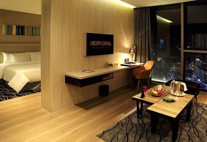 Liberty Central Saigon Citypoint Hotel room. Gay-friendly hotel in Ho Chi Minh City. Modern interior, desk, city view, bed.