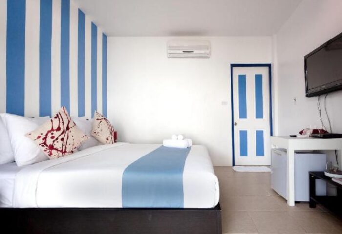 Lima Coco Resort gay-friendly hotel room. Interior with striped wall, bed, TV, and mini-fridge. Gay travel in Lima, Peru.