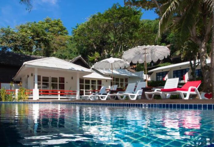 Lima Coco Resort pool view. Gay-friendly hotel with white bungalows, sun loungers, and umbrellas. Ideal for gay men travel.