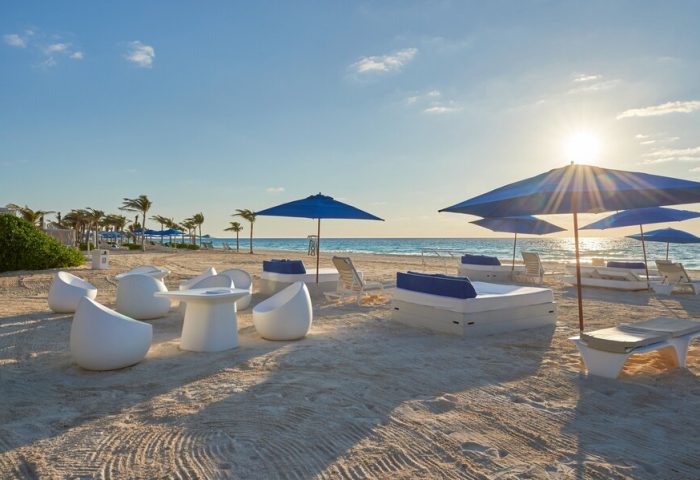 Beachfront view at Live Aqua Beach Resort Cancun, an all-inclusive, adults-only, gay-friendly hotel. Lounge chairs and umbrellas on the sand.