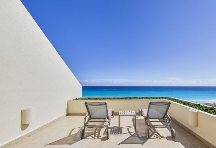 Balcony view at Live Aqua Beach Resort Cancun, an adults-only, all-inclusive, gay-friendly hotel. Ocean view with two lounge chairs.