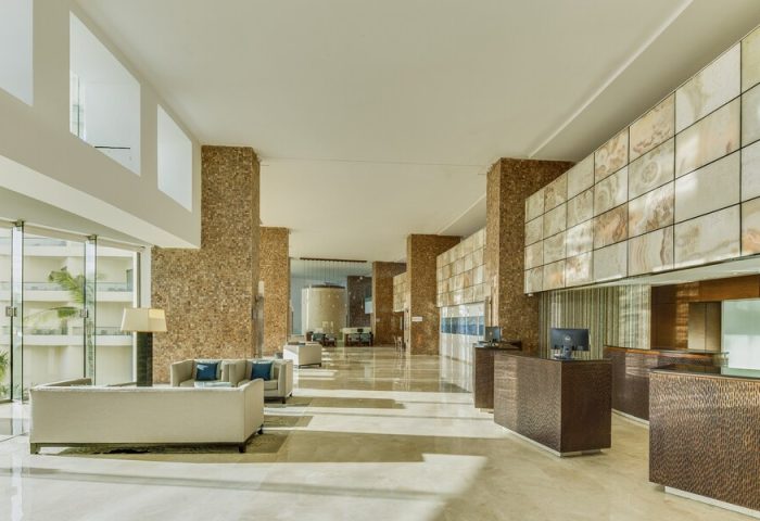 Lobby at Live Aqua Beach Resort Cancun, an adults-only, all-inclusive, gay-friendly hotel. Modern design with textured columns and seating area.