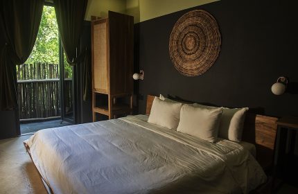 Loba Tulum Male Only gay-friendly hotel room. Bed, balcony, and rustic decor create a relaxing vibe for gay travelers in Tulum.