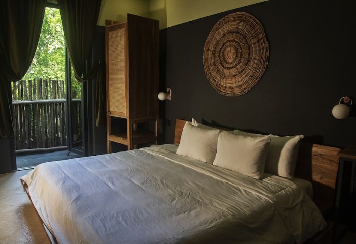Loba Tulum Male Only gay-friendly hotel room. Bed, balcony, and rustic decor create a relaxing vibe for gay travelers in Tulum.