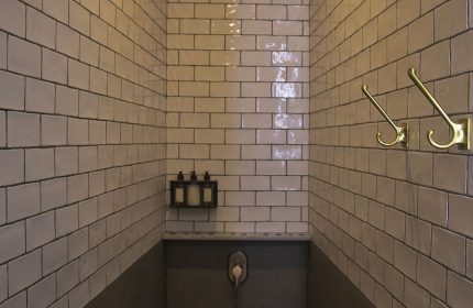 Shower in Loba Tulum Male Only, a gay-friendly hotel. Features include tile, stone floor, shower head, hooks, and toiletries. Great for gay travel.