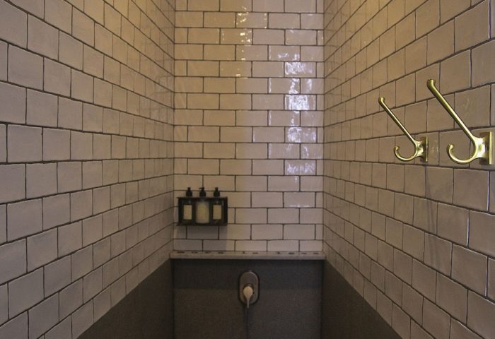 Shower in Loba Tulum Male Only, a gay-friendly hotel. Features include tile, stone floor, shower head, hooks, and toiletries. Great for gay travel.