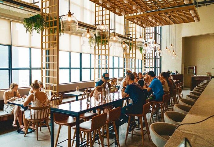 Lub D Philippines Makati gay-friendly hotel interior. People dining in a stylish, well-lit space with modern decor and large windows.