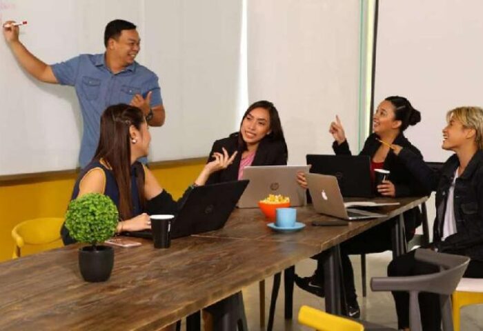 Team meeting at Lub D Philippines Makati, a gay-friendly hotel. People with laptops at a table, one person at the whiteboard.