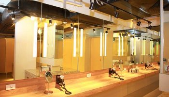 Lub d Phuket Patong gay-friendly hotel's bathroom. Long mirror over wood counter with hair dryers and outlets. Modern, well-lit design.