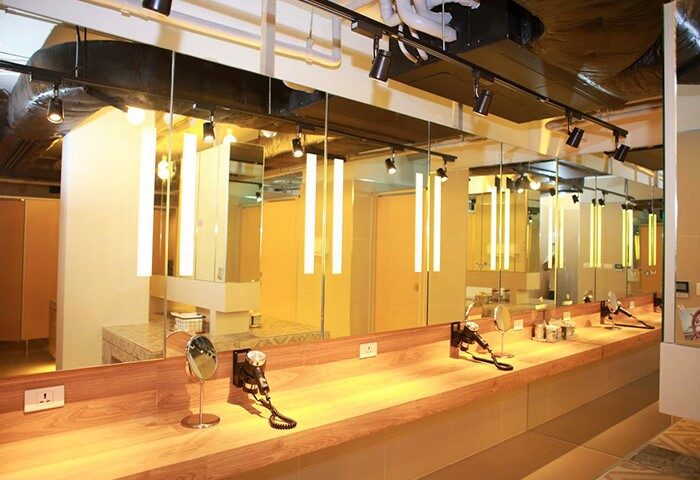 Lub d Phuket Patong gay-friendly hotel's bathroom. Long mirror over wood counter with hair dryers and outlets. Modern, well-lit design.
