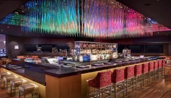 Luxor Hotel's bar with colorful ceiling decor. A gay-friendly hotel, it's a great spot for gay men's travel, offering a welcoming atmosphere.
