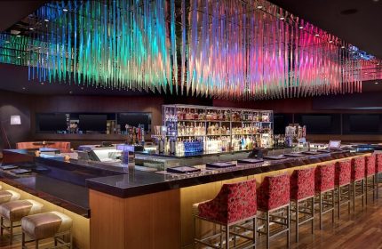 Luxor Hotel's bar with colorful ceiling decor. A gay-friendly hotel, it's a great spot for gay men's travel, offering a welcoming atmosphere.