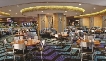 Interior of the Luxor Hotel, a gay-friendly hotel. Tables and chairs are set for dining, with Egyptian-themed decor. Las Vegas travel.