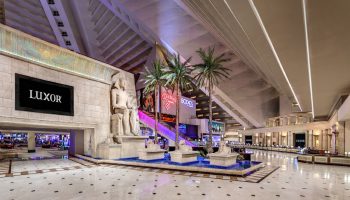 Luxor Hotel interior. Gay-friendly hotel with Egyptian theme, statues, palm trees, and pyramid architecture. Las Vegas travel advice.