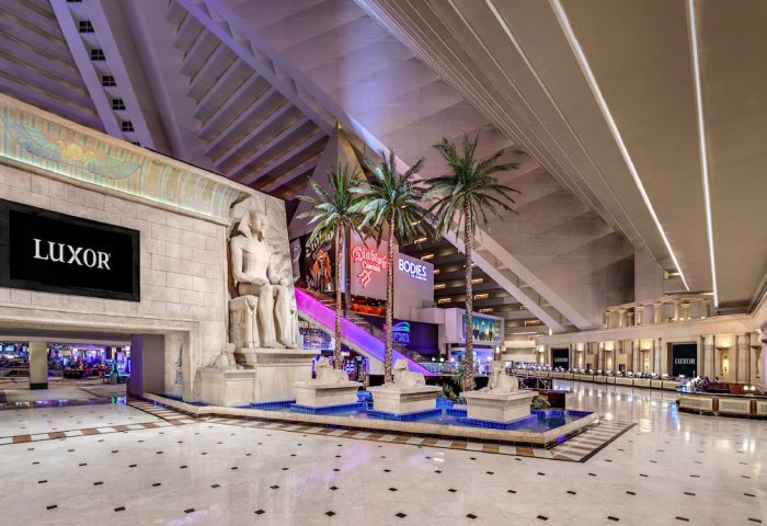 Luxor Hotel interior. Gay-friendly hotel with Egyptian theme, statues, palm trees, and pyramid architecture. Las Vegas travel advice.
