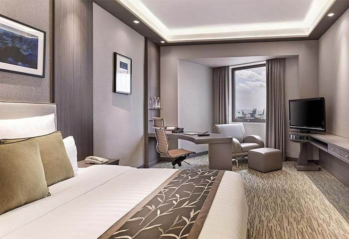 M Hotel gay-friendly hotel room. Modern interior with bed, desk, TV, and seating area. Comfortable stay for gay travelers.