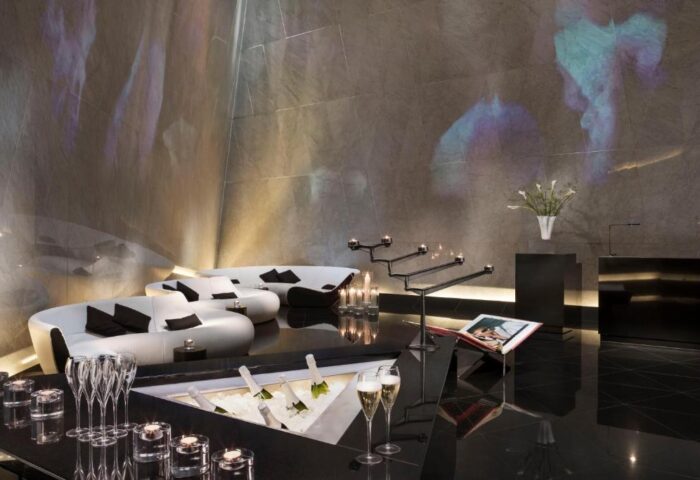 Gay-friendly ME London Hotel interior. Champagne, candles, and stylish seating. Pet-friendly hotel with modern design for gay travelers.