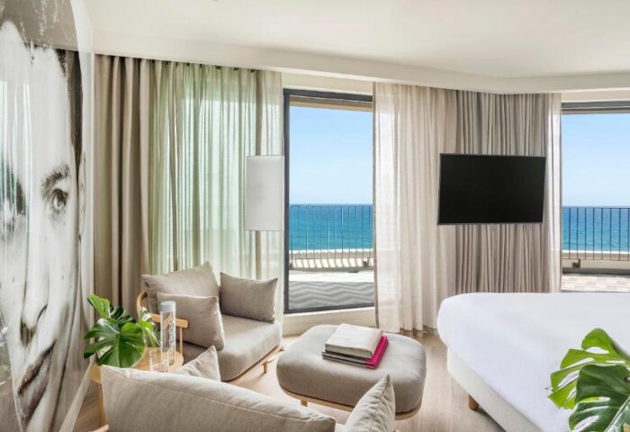 ME Sitges Terramar gay-friendly hotel room with ocean view. Pet-friendly hotel with modern decor, balcony, and comfortable seating.