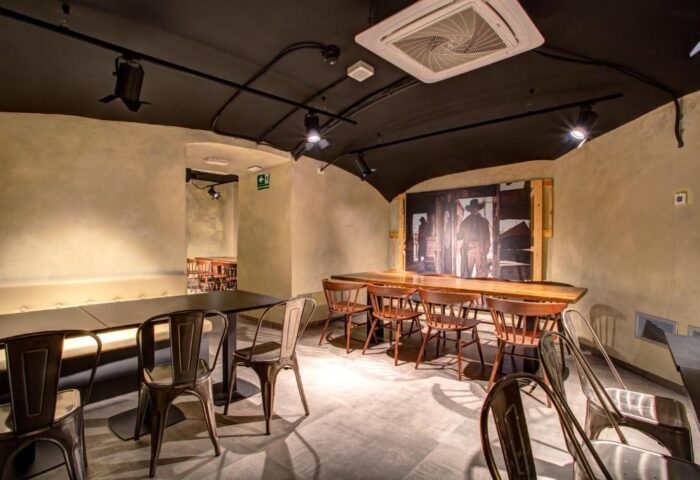 MEININGER Roma Termini gay-friendly hotel dining area. Tables and chairs with a cowboy-themed mural. A great place to meet new people.