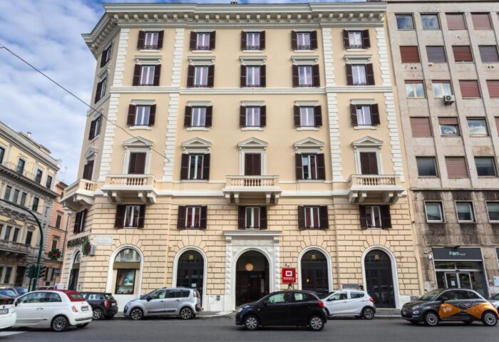 MEININGER Roma Termini gay-friendly hotel exterior. A multi-story building with cars parked on the street. Great location for gay travelers.