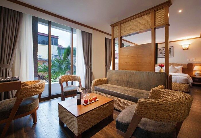 MK Premier Boutique Hotel room. Gay-friendly hotel with seating area, woven furniture, wine, and view. Ideal for gay men's travel.