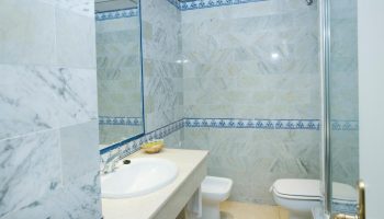 MS Aguamarina Suites gay-friendly hotel bathroom. Features marble tiles, a sink, toilet, and shower. Ideal for gay men's travel.