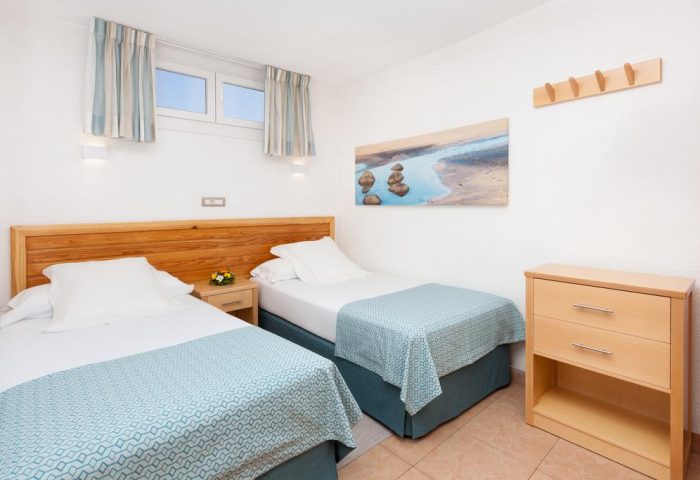 MUR Aparthotel Buenos Aires Gran Canaria room. Twin beds, light wood furniture, beach art. Gay-friendly hotel in Gran Canaria.