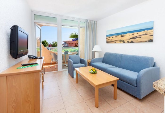 MUR Aparthotel Buenos Aires Gran Canaria living room. Gay-friendly hotel apartment with sofa, balcony, and TV. Perfect for Gran Canaria holidays.
