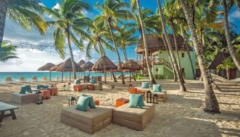 Mahekal Beach Front Resort and Spa: Gay-friendly hotel with beachside seating, palm trees, and ocean views. Perfect for gay men's travel.