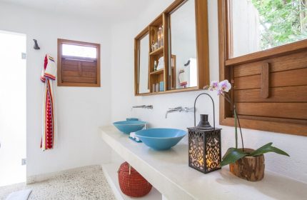 Bathroom at Mahekal Beach Front Resort and Spa, a gay-friendly hotel. Blue sinks, wood accents, and a lantern create a relaxing vibe.