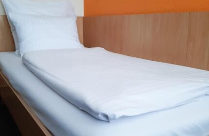 Mainhaus Stadthotel Frankfurt room. Single bed with white linens. Gay-friendly hotel in Frankfurt near gay nightlife.