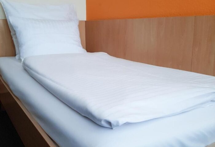Mainhaus Stadthotel Frankfurt room. Single bed with white linens. Gay-friendly hotel in Frankfurt near gay nightlife.