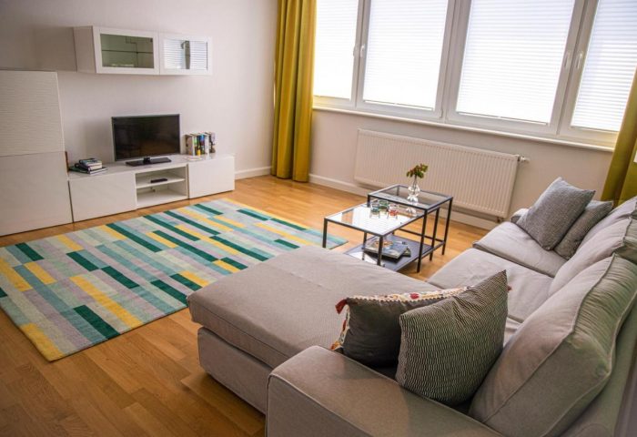 Mainhaus Stadthotel Frankfurt gay-friendly hotel room. Living area with couch, TV, & colorful rug. Modern design for gay travelers.