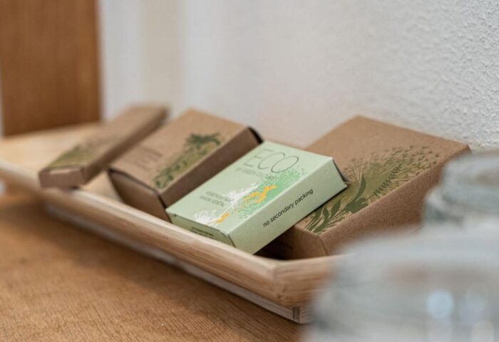 Bathroom amenities at Mainhaus Stadthotel, a gay-friendly hotel in Frankfurt. Eco-friendly toiletries on a wooden tray. Sustainable travel.