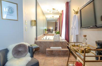 Maison Cartier Montreal gay-friendly hotel room. Bathroom with tub, TV, and minibar. Upscale decor. Perfect for gay travelers in Montreal.