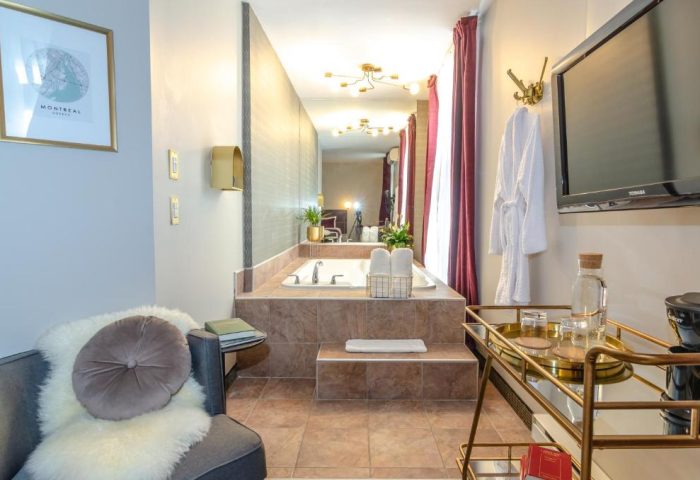 Maison Cartier Montreal gay-friendly hotel room. Bathroom with tub, TV, and minibar. Upscale decor. Perfect for gay travelers in Montreal.