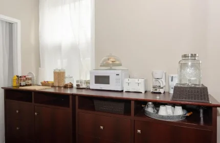 Maison Cartier Montreal: Buffet in a gay-friendly hotel room. Microwave, toaster, coffee maker, and water dispenser on a dark wood dresser.