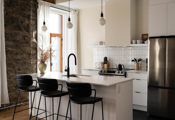 Maison Place Royale kitchen. Gay-friendly hotel by Luxury In Transit features modern design, island, & stainless steel fridge. Vacation travel.