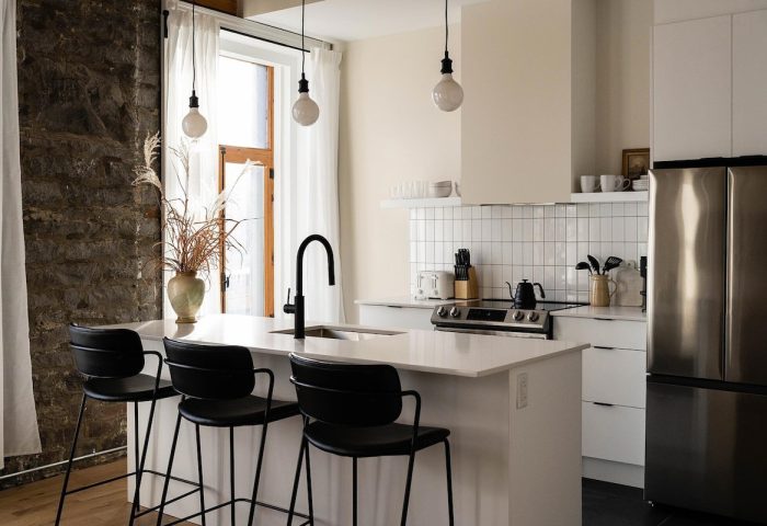 Maison Place Royale kitchen. Gay-friendly hotel by Luxury In Transit features modern design, island, & stainless steel fridge. Vacation travel.