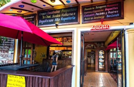 Maison Tulum gay-friendly hotel cafe. Open sign, menu boards, and outdoor seating. Crepes, salads, pastries, and Mexican breakfast options.