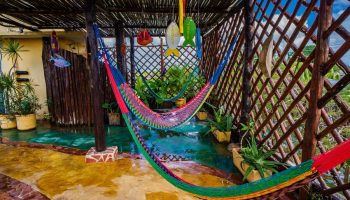 Maison Tulum gay-friendly hotel: Hammocks hang over a shallow pool in a covered patio. Tropical plants add to the relaxing vibe.