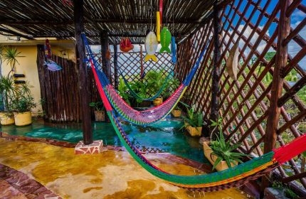 Maison Tulum gay-friendly hotel: Hammocks hang over a shallow pool in a covered patio. Tropical plants add to the relaxing vibe.