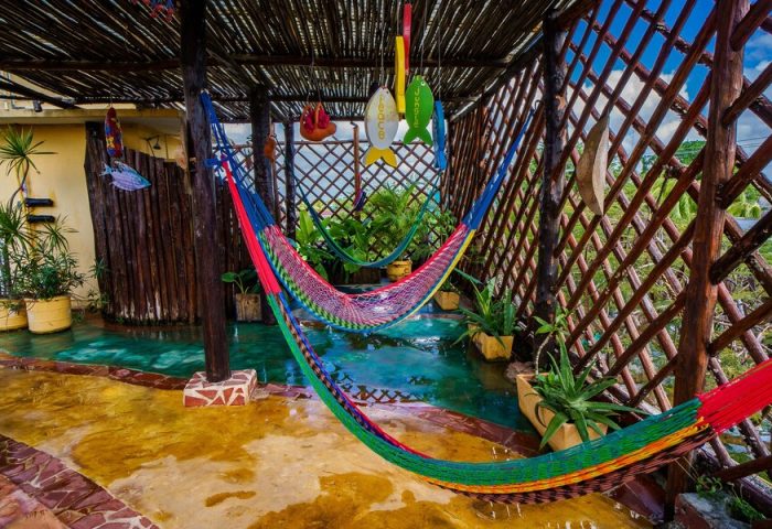 Maison Tulum gay-friendly hotel: Hammocks hang over a shallow pool in a covered patio. Tropical plants add to the relaxing vibe.