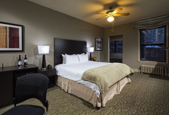 Majestic Hotel Chicago guest room. Gay-friendly hotel features a king bed, wine, city views, ceiling fan, and warm, inviting decor.