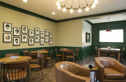Majestic Hotel Chicago interior. Gay-friendly hotel with round tables, leather chairs, & framed portraits. A comfortable, stylish space.