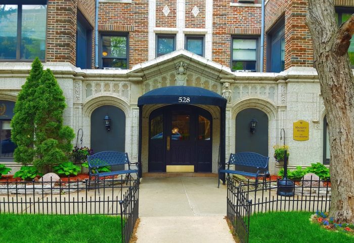 Majestic Hotel Chicago entrance. Gay-friendly hotel with a charming facade, benches, and well-manicured landscaping. Welcoming spot for gay travelers.